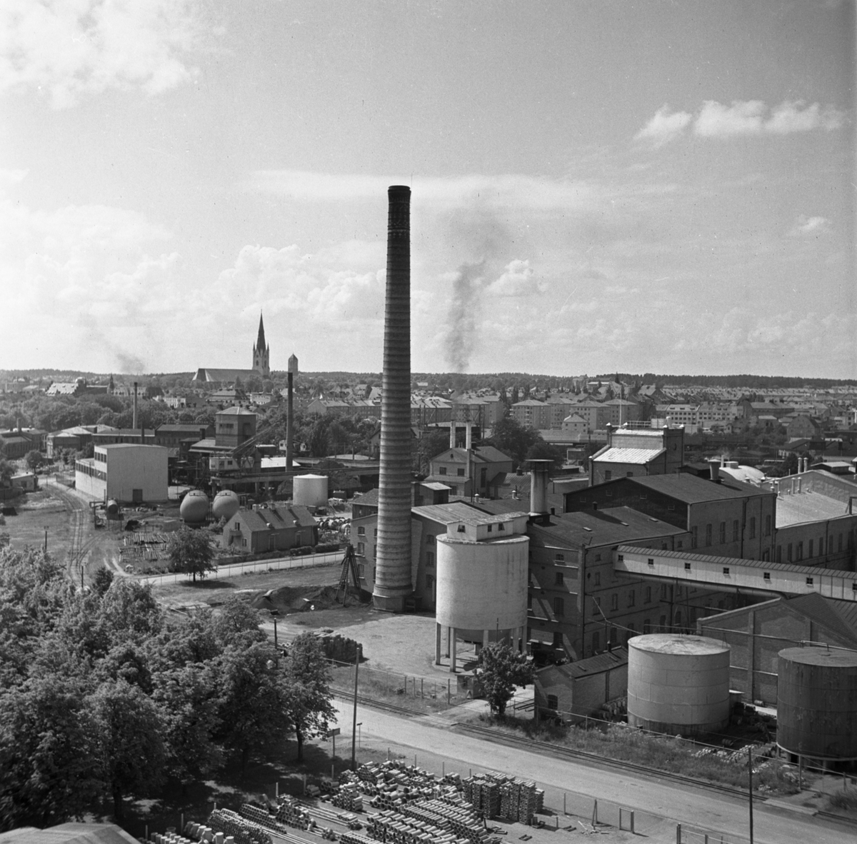 Linköpings sockerbruk, närmast i fotografiet, var i bruk till år 1955, vilket även ungefär harmonerar med bildens tillkomsttid. Bortom sockerbruket utbreder sig gasverksområdet. I fonden staden från nordost.