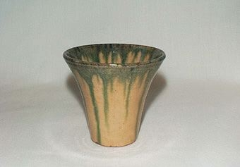 Gul vas av lergods med grön rinnande dekor både in- och utvändigt.