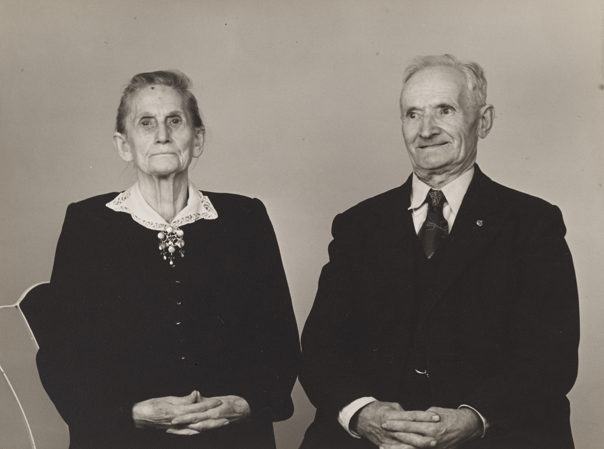 En eldre kvinne og mann i halvfigur, med foldede hender