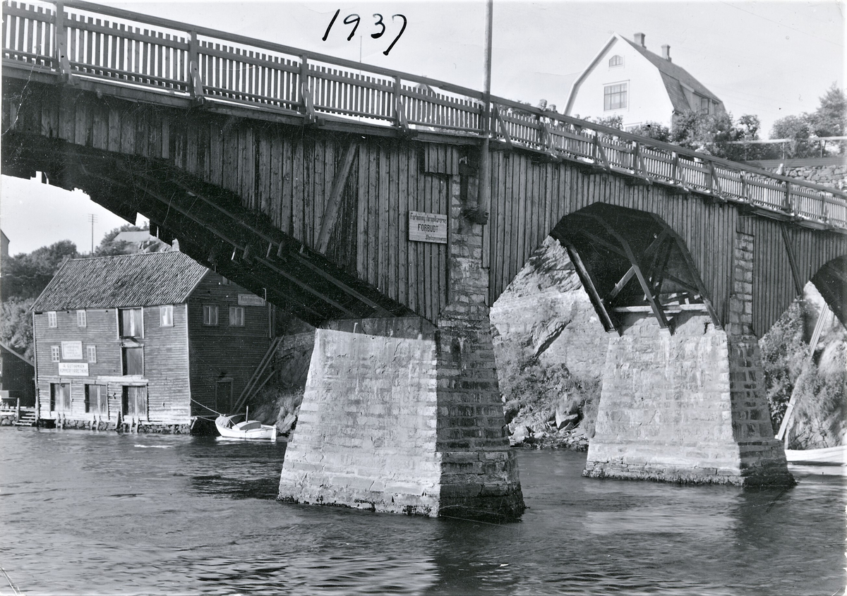Den gamle broa mellom fastlandet og Hasseløy. Over broa ses Strandgata 226 på Havnaberg. Ved sjøkanten ligger A. Guttormsens hummer- og fiskeforretning i Smedasundet 114.