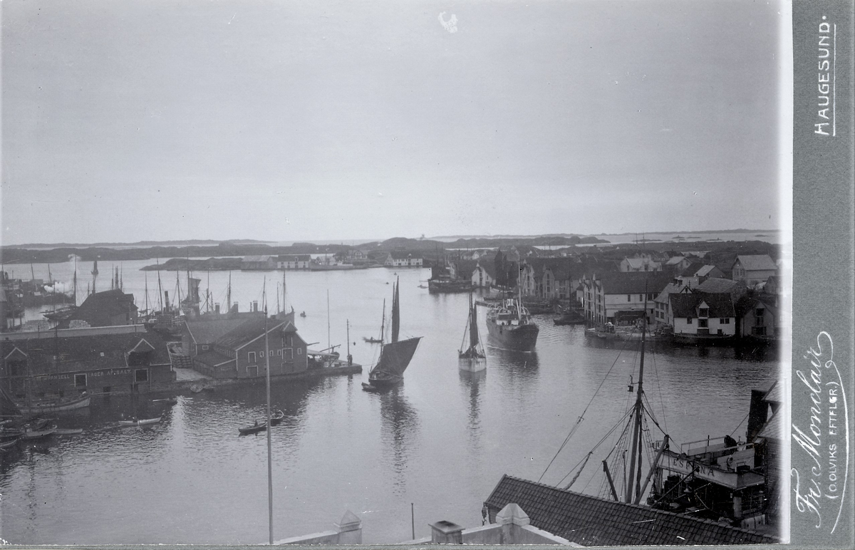 Kortaneset i Haugesund sett mot vest. Robåter, seilbåter og et dampskip er på vei inn og ut fra byen. På huset til venstre står det "Wrangell. Lager av salt."