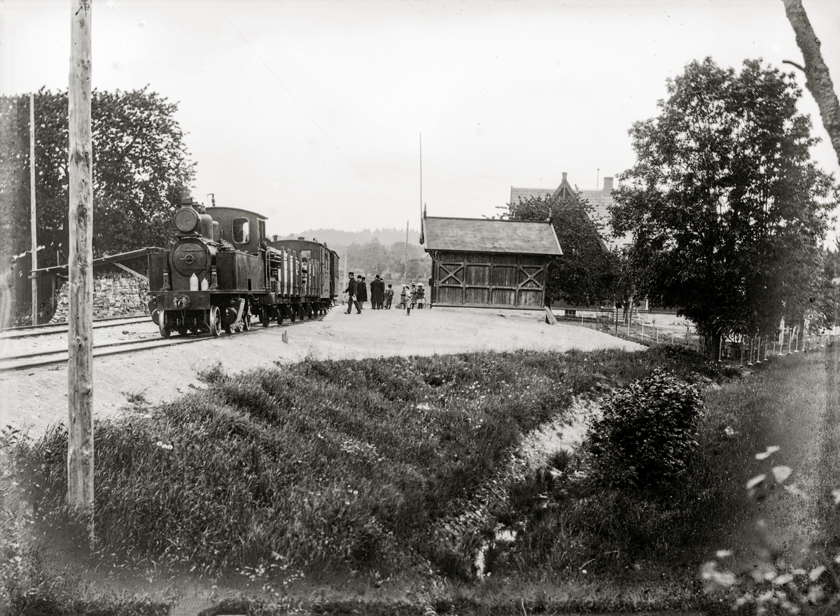 Aust-Agder, Øyestad kommune, Rygene jernbanestasjon, Grimstad-Frolandbanen,  Banen var en privatbane som gikk mellom Rise nord for Arendal til Grimstad, åpnet i 1907, ble tatt over av NSB i 1912 og nedlagt i 1961. Foto er tatt ved Rykene stoppested, Banen hadde to lokomotiver, en 3. klassevogn og en konduktørvogn, godsvogner, i huset bak (ser gavl) bodde distriktslege Axel Smith Arbo,