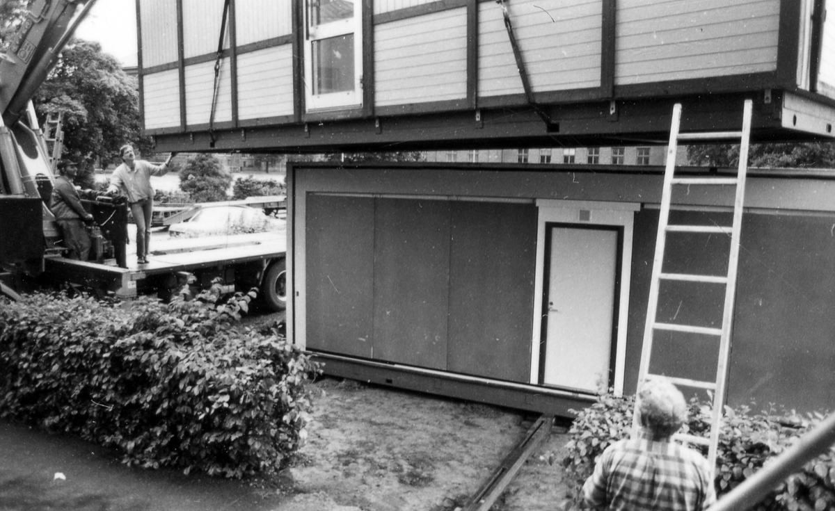 Leverans av två kontorsmoduler den 26 juni 1985.
Foto 1-2 Avvävning av marken.
Foto 3-7 Bakre modulen lyfts av med kran.
Foto 8-15 Främre modulen lyfts på plats.