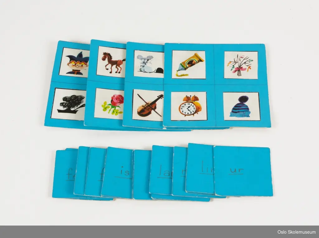 Lese-/norskspill som består av fire blå spillbrett samt kvadratiske kort i blå papp. Hvert spillbrett har fire illustrasjoner. Kortene har et ord som er håndskrevet med tusj.