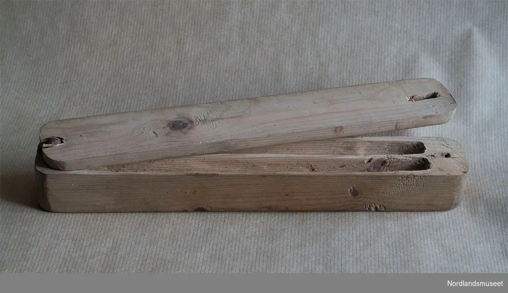 Hjemmelagget penal av furu, svært enkelt tillaget, kanskje et sløydarbeid? Lokket blir holdt av ei skrue og kan skyves til side.