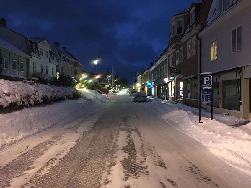 En vintergata i Gränna med snövallar på bägge sidor av gatan. Billjus på väg i riktning mot fotografen. Det är Brahegatan söderut, tisdag morgon kl 07.43 den 16 januari 2024.