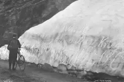 Syklist ved ei snøfonn på Geirangerfjellet