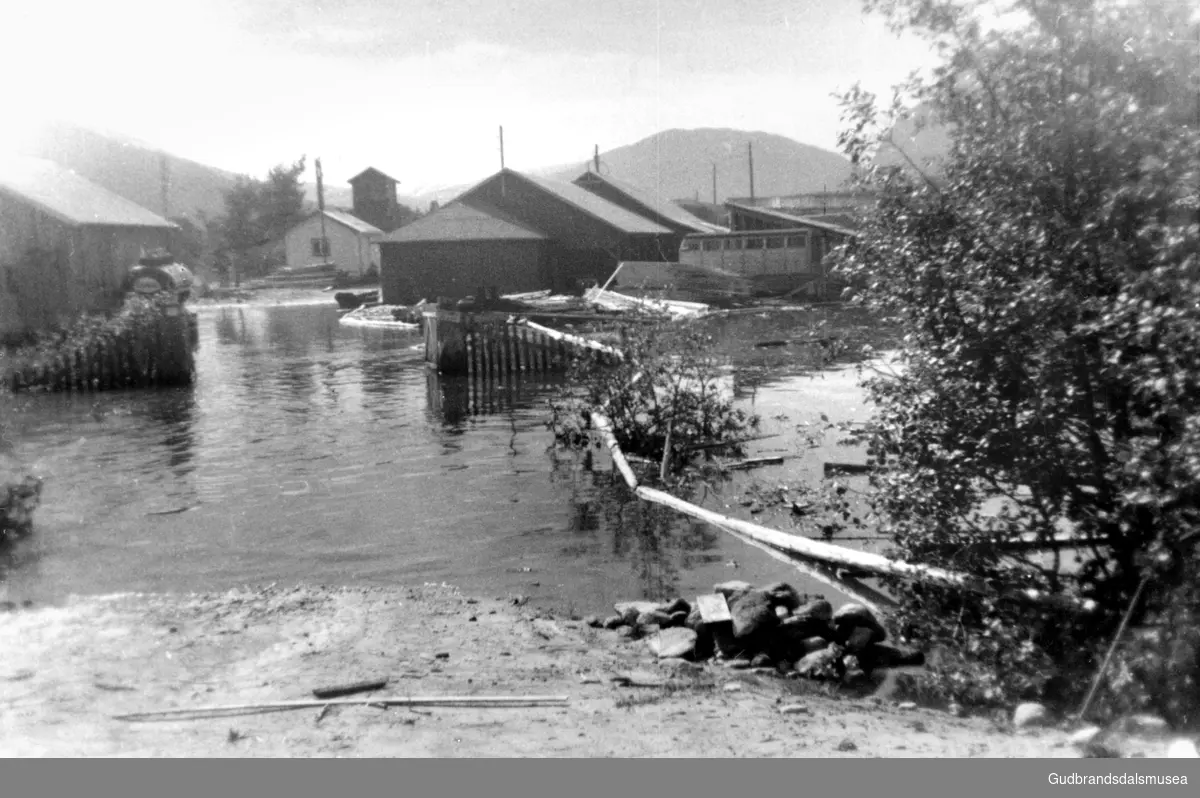 Nordberg Sag og Høvleri under flaumen i 1958.
Det er lagt ut lense for å hindre at trelast reiser i elva