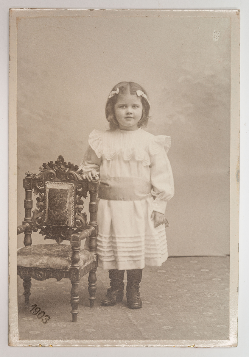 Visitkortsporträtt av Gulli Zachau, 4 år. Fotografiet sitter i fotoalbum som tillhört Gertrud Zachau. Fotografiet sitter på sida 34.