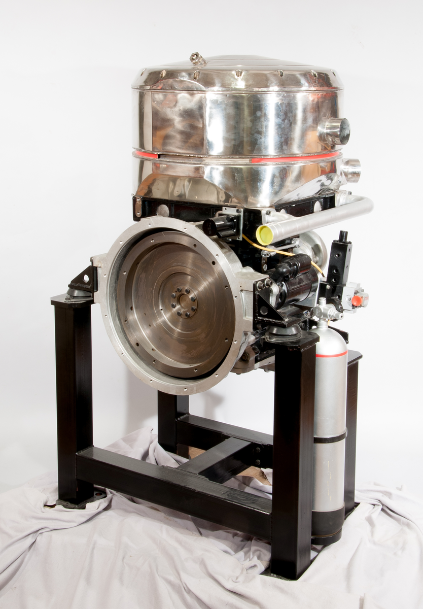 Stirlingmotor som inte använder luft som arbetsmedium utan komprimerad heliumgas, effekten är 100hk (75kW) med en verkningsgrad på 40%.
Uppskuren för demonstration.