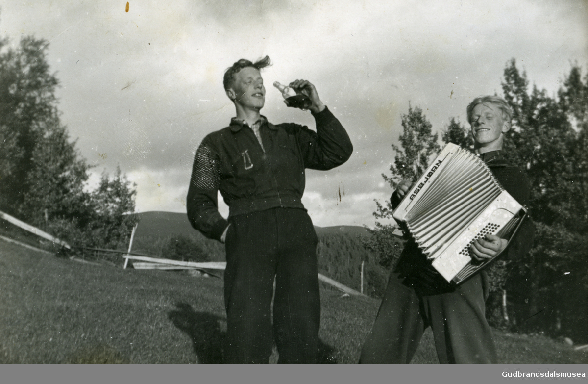 Ola Odnes med flaska og Asbjørn Brun 1929-1991 med trekkspillet 

Første eier av foto; Ola Odnes 1922-2020, Vågå. Innlånt og skænna fra Kari Margot Odnes 2023