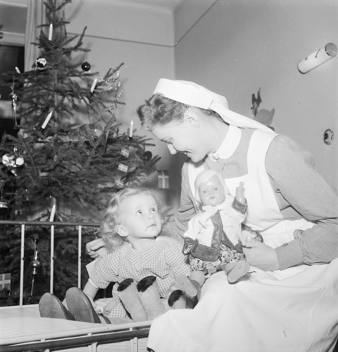 En sjuksköterska med en flicka i sjukhussäng, Uppsala julen 1951