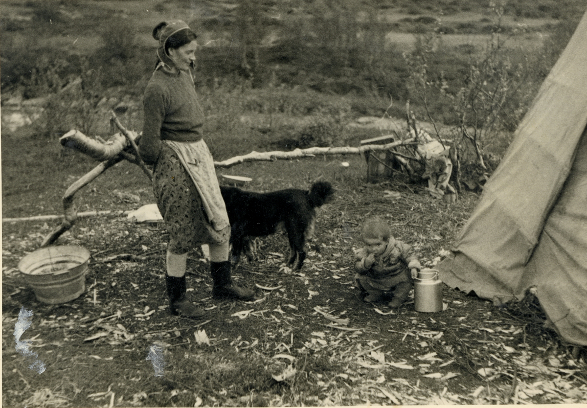 Samisk kvinne og barn foran lavo.