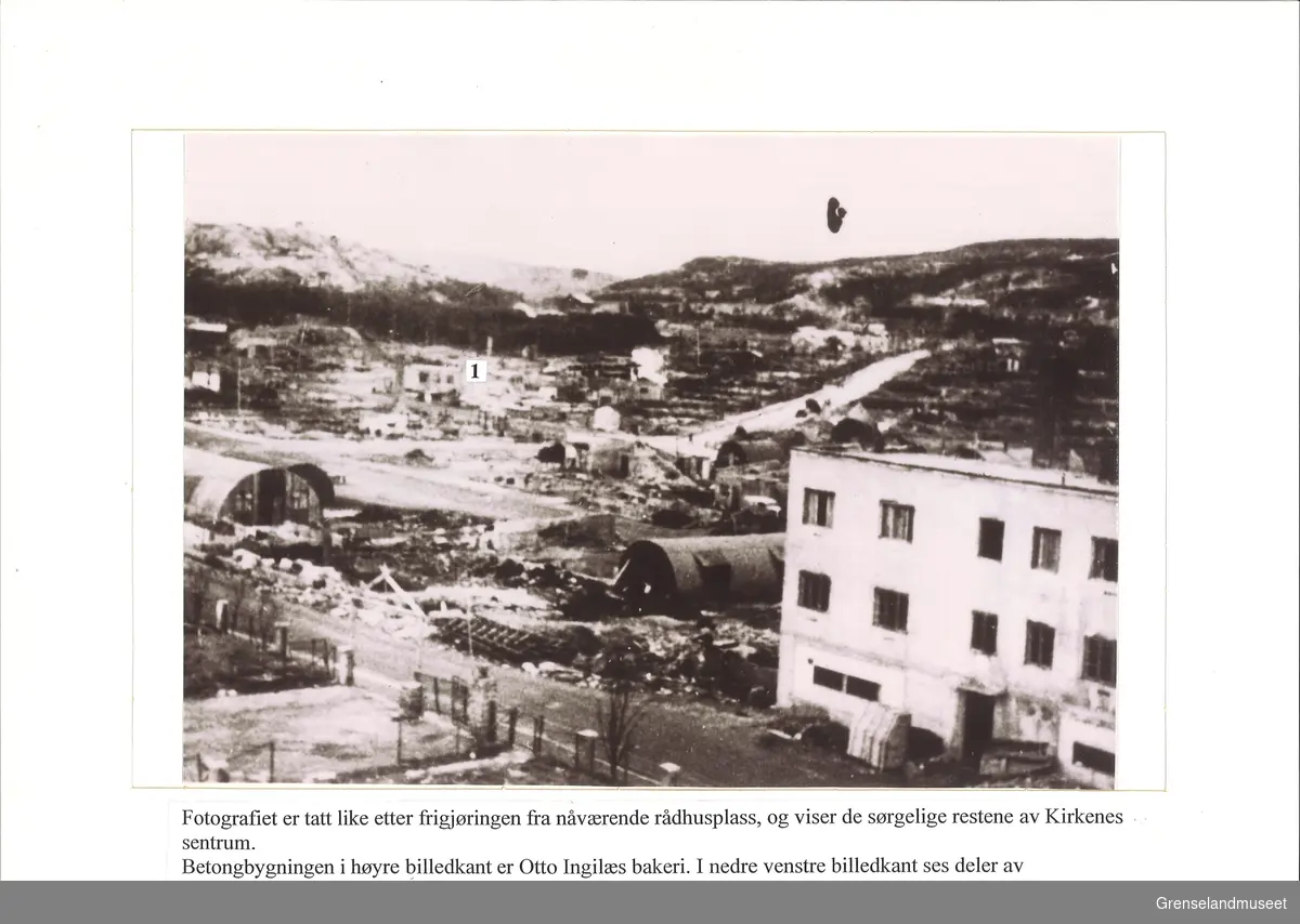 Kirkenes i ruiner rett etter at tyskerne trakk seg ut av Øst-Finnmark på høsten 1944. Bildet er tatt fra den nåværende rådhusplassen med betongbygning til høyre som var Otto Ingilæs bakeri og nede til venstre kan man se deler av kirkegårdsgjerdet. Merket med "1" tall er restene av det gamle politikammeret i Kirkenes. 