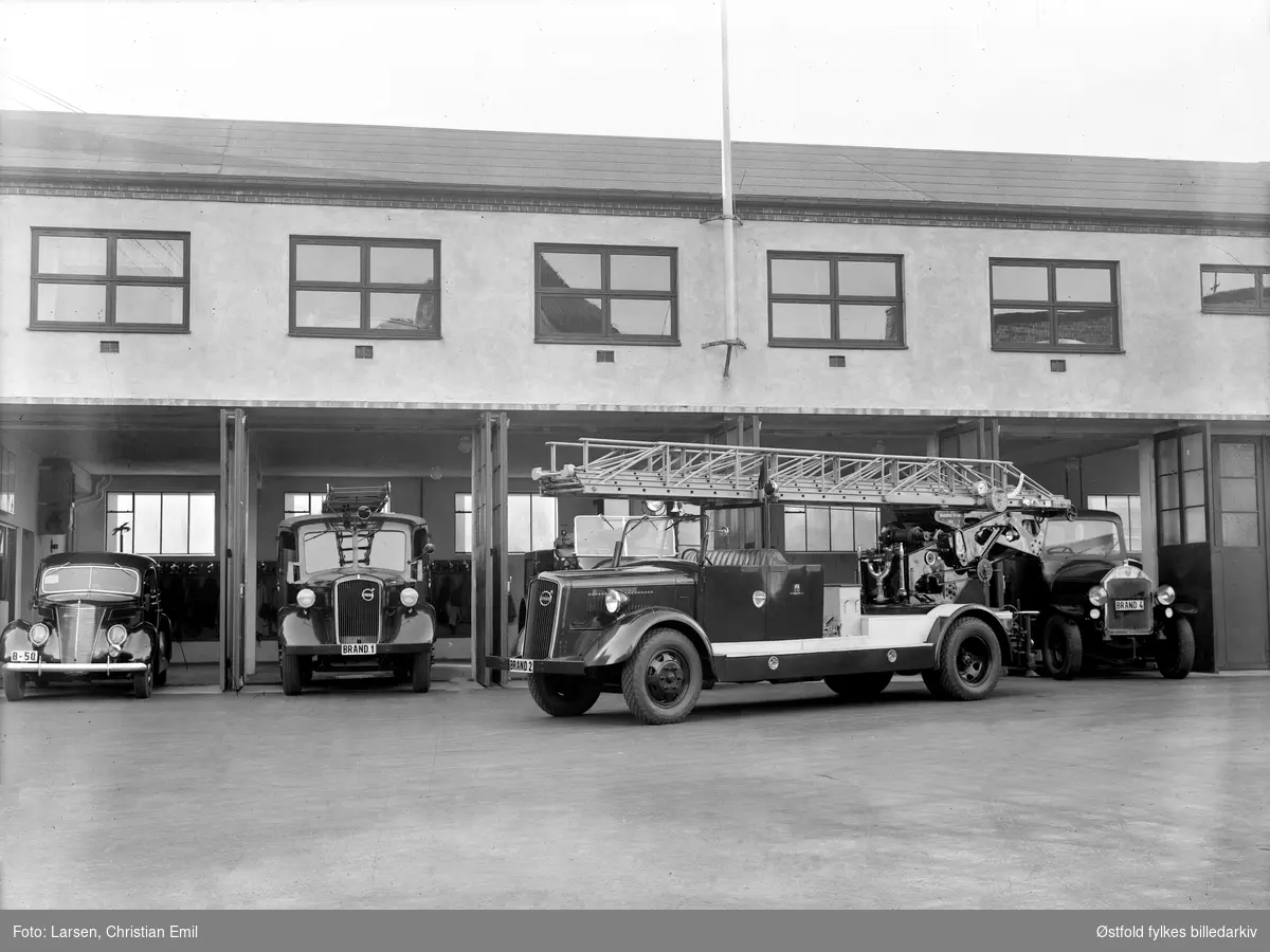 Sarpsborg brannstasjon med fire brannbiler eller utrykningsbiler, de tre til høyre er produsert av Volvo. Den største bilen har Magirus-stige. 
Kjennetegn Brand 1, Brand 2, Brand 4, bilen til venstre har kjennetegn  B-50 en  Ford V8 1937-modell.