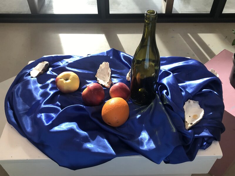 Stilleben med frukt, flaske og østers på en blå duk