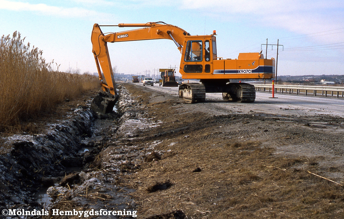 Gatukontoret rensar diken vid Söderleden i Mölndal då det var en ½ meter tjäle, år 1987. K 6:19.