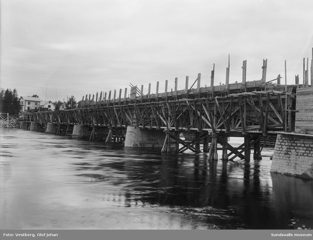 Vy söderut över Ljungan vid det pågående bygget av den nya betongbron i Njurundabommen. Bakom brobygget skymtar den gamla träbron.