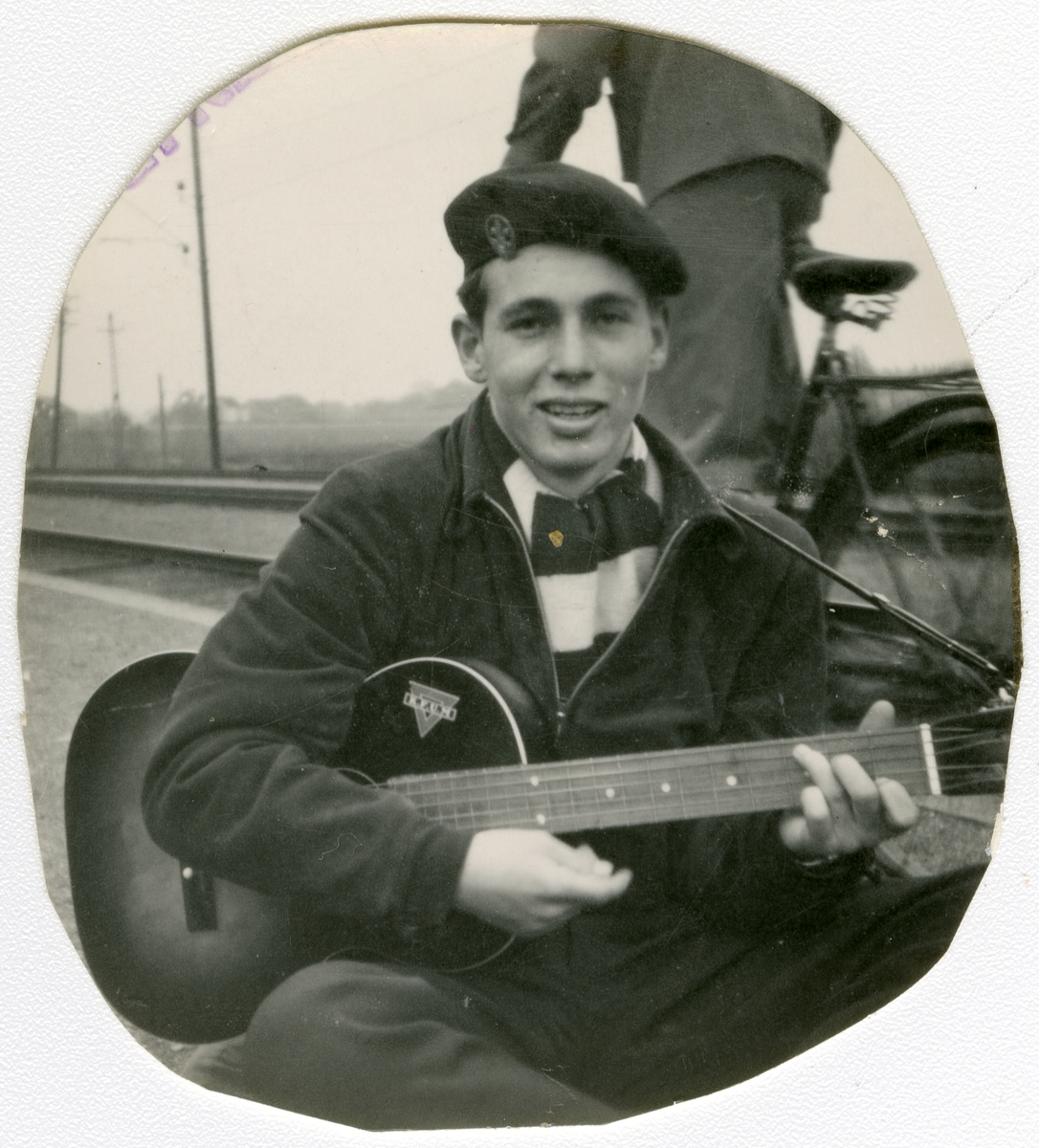 Foto av forfatter Tor Åge Bringsværd med gitar på 1950-tallet

KFUM klistremerke kan sees på gitaren