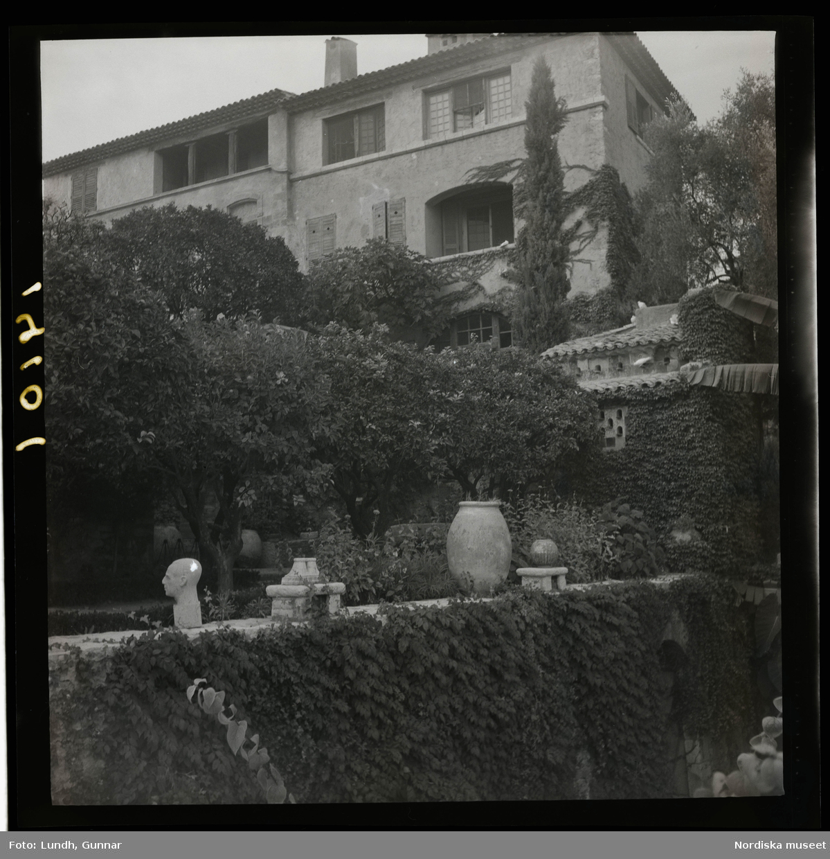 1950. Frankrike. Stenhus ovanför en mur med kruka