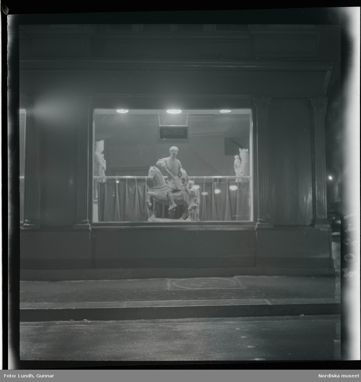 1950. Paris. Riddarstaty i skyltfönster kväll.