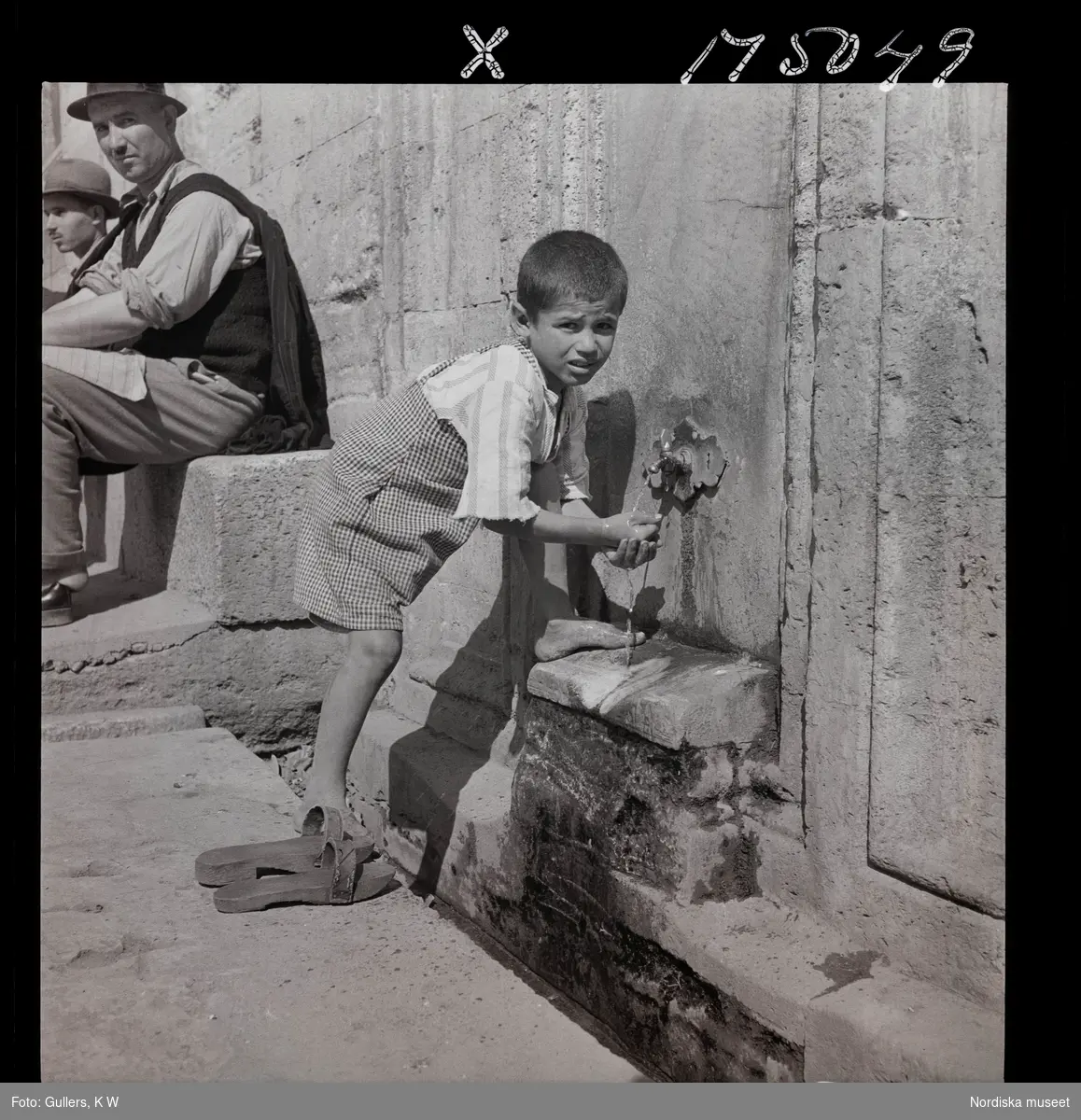 1717/L Istanbul allmänt. En pojke tvättar sig vid en springbrunn/ fontän.