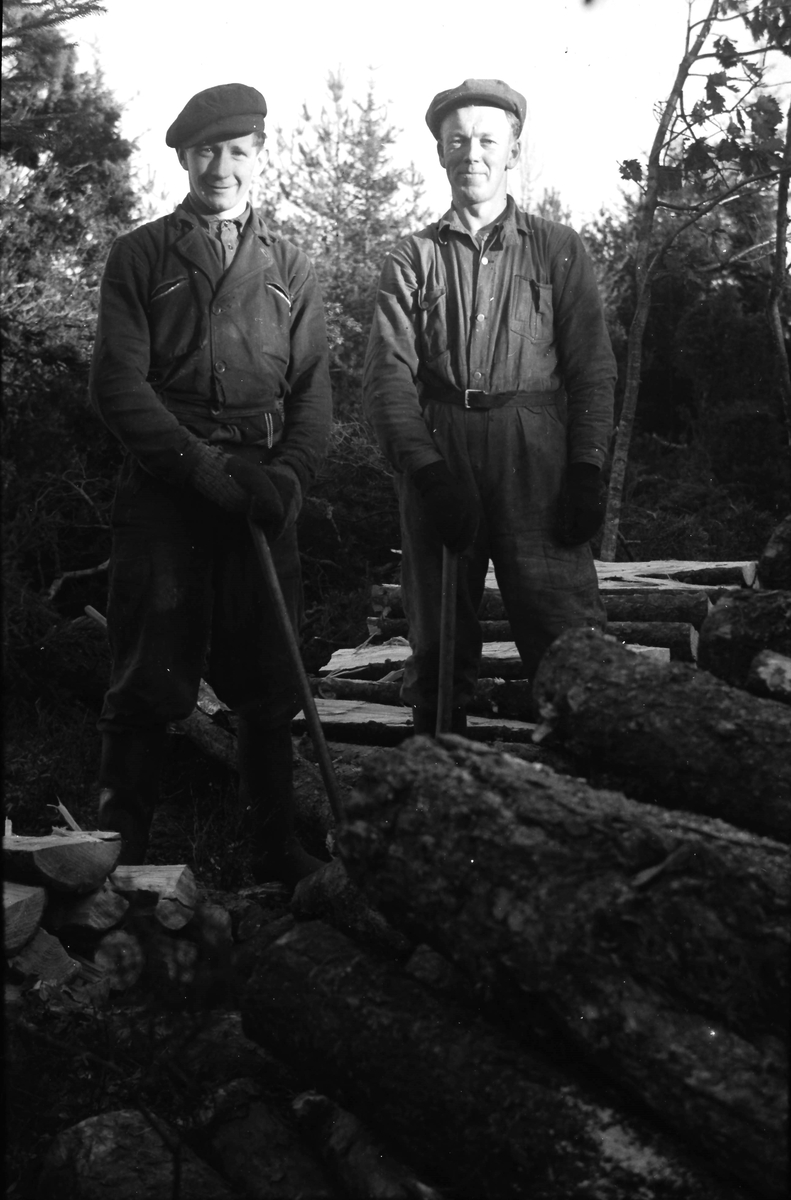 Två skogshuggare klyver stockar. Mannen till vänster kallas Målarns Gustav och till höger kan det vara Karl Lundgren eller Bengt Rosengren.