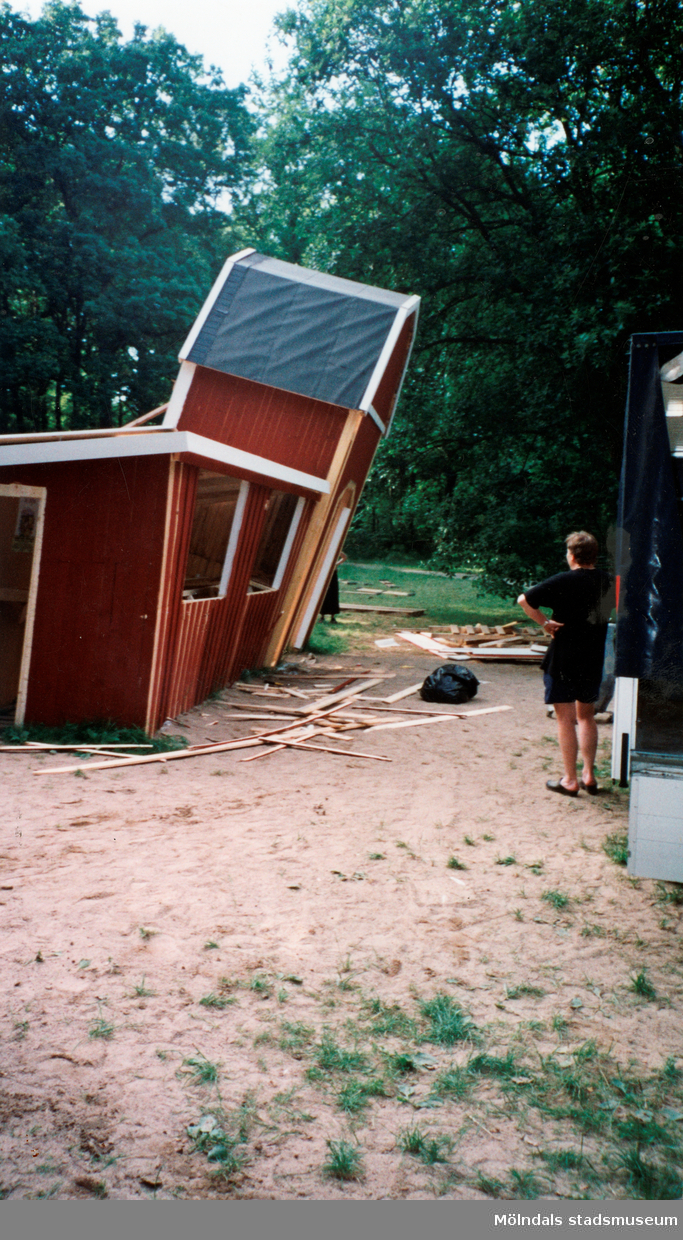 Sommarspelet/barnteaterföreställningen "Rasmus på luffen" 1999 vid Byxorna i Gunneboskogen (korsningen Christina Halls väg/John Halls väg). En sned byggnad, troligtvis föreställningens kiosk, monteras ned.