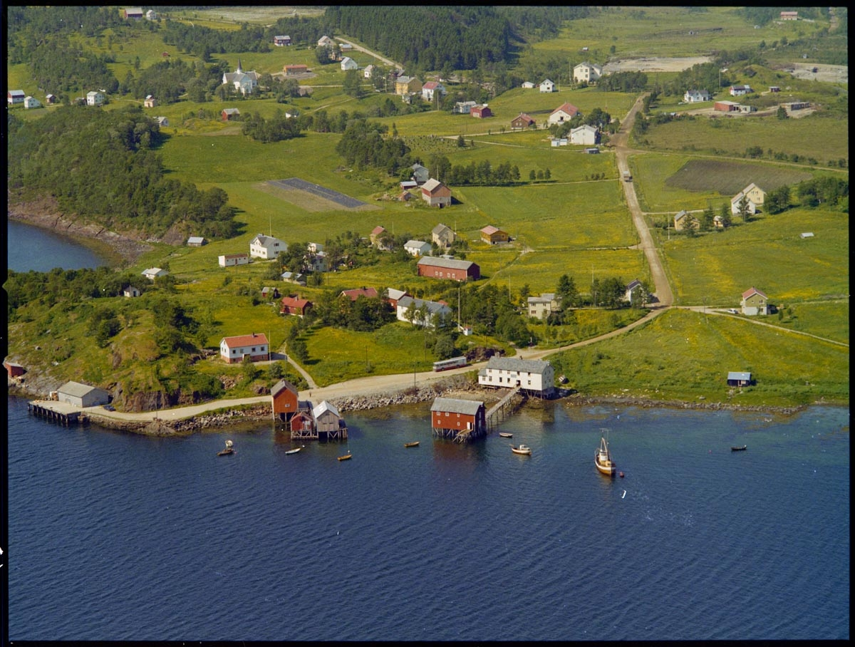 Leirfjord,Leland. Flyfoto av Leland, med Nedre-Leland og Leland havn. Nederst, midt i bildet ligger butikken til Johan Bergh (nå museum), Bergh-brygga. Øverst i bildet, mot venstre, ligger Leirfjord kirke.