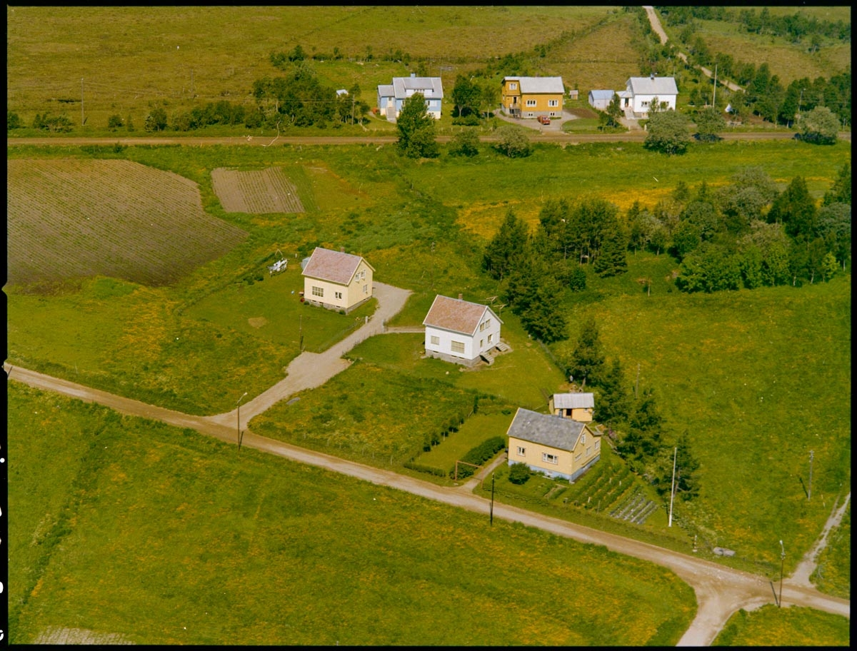 Leirfjord,Leland. Flyfoto. De tre fremste boligene i bildet er bygget som kommunale tjenesjeboliger. Her konne blandt annet lærere bo.
