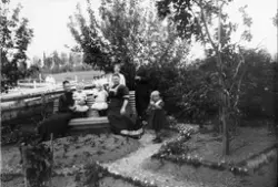 Gruppebilde i hage, Ulefoss. Fra venstre på benken: 1. fru A