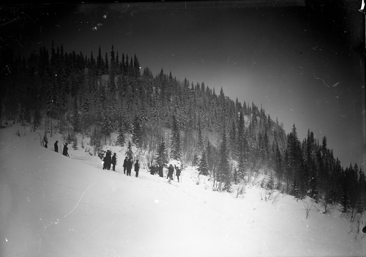 Vintermotiv med menn i skibakken.

Fotosamling etter fotograf og skogsarbeider Ole Romsdalen (f. 23.02.1893).
