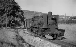 Damplokomotiv type 45a nr. 5 med persontog kjører ut fra Dra