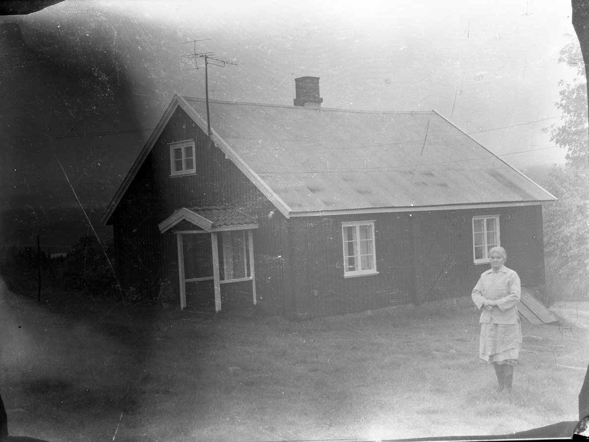 Portrett av kvinne utenfor hus, trolig Asta Romsdalen. Ole Romsdalens kone 

Fotosamling etter fotograf og skogsarbeider Ole Romsdalen (f. 23.02.1893).