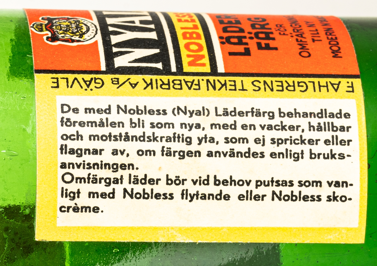 Glasflaska, grön, med kork. Etikett med text "Nyal Nobless Läderfärg".