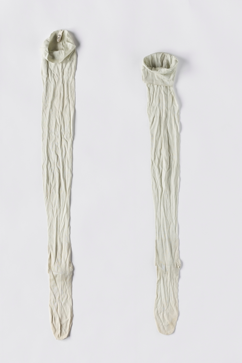 Strikkede turkise strømper i kunstsilke (viskose). Foten er formsydd. Det er strikket hullmønster fra hælen og oppover ankelen.