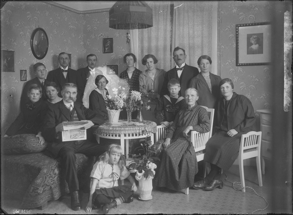 Fotografering beställd av Kjellin. Föreställer det äldre paret Johan August Kjellin (1852-1930) och hans hustru Augusta Vilhelmina Persdotter (1860-1936) sittandes vid bordet. Bosatta på Nygård 12. De andra är ej identifierade. Möjligen är bilden tagen på mannens födelsedag den 4 december 1927.
