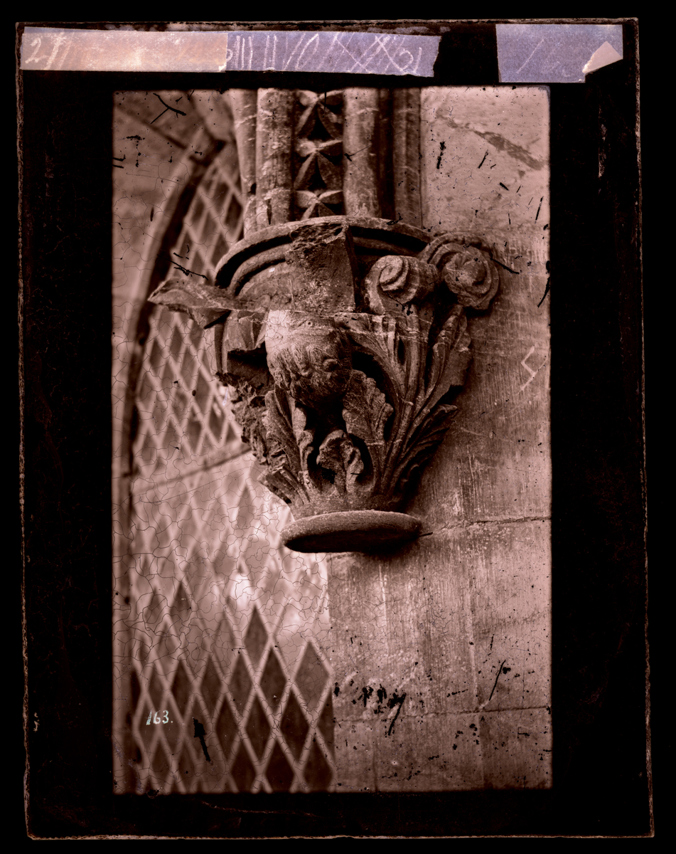 Vinduskapitel med bladverk fra oktogonen i Nidarosdomen. I bakgrunnen gammelt blyglassvindu. Bildet er tatt før restaurering.