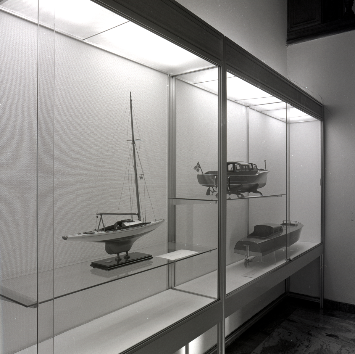 Utställning i trappmonter med fartygsmodeller av en sgelbåt och två mahognyracers.