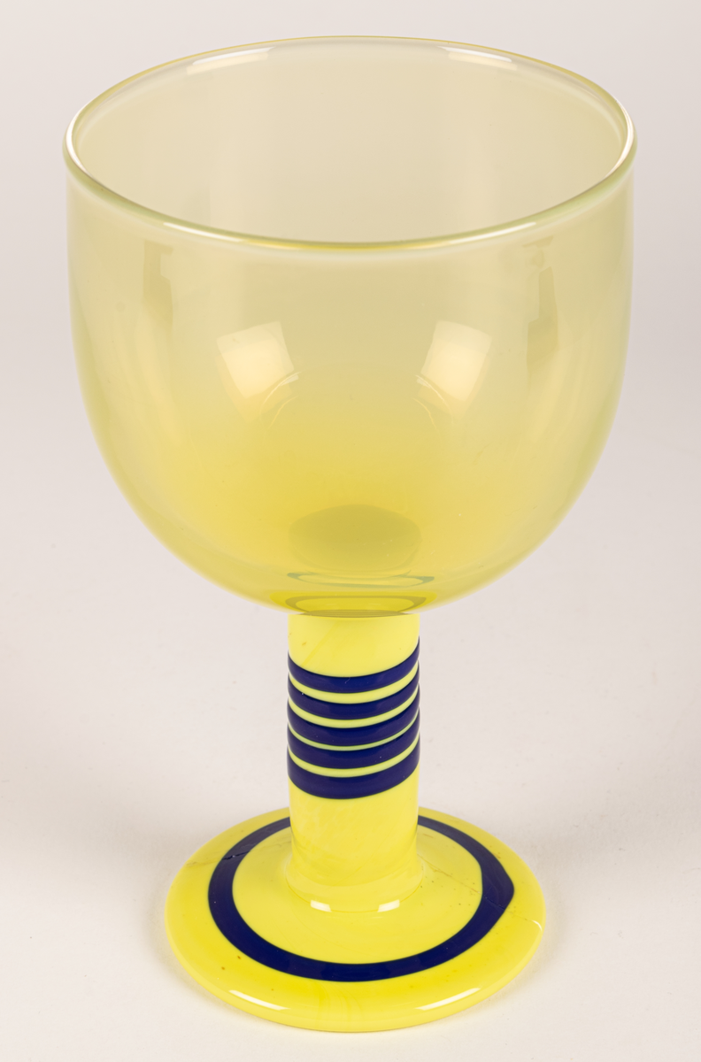 Popglas, gult med blåa ränder på foten.