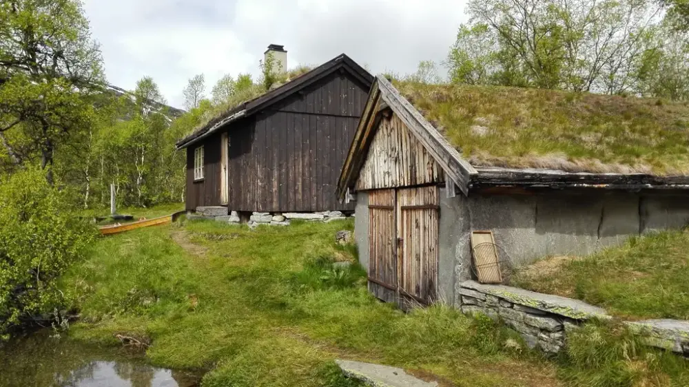 Naust og liten hytte ved fjellvann