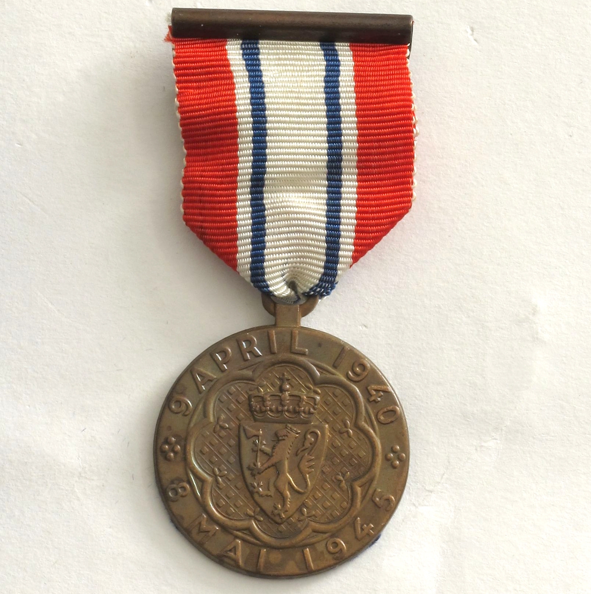 Medalje er i bronse, på advers er riksvåpenet med omskrift «9 APRIL 1940 * 8 MAI 1945 *». På revers kongeflagget, handelsflagg og orlogsflagg og innskrift «DELTAGER I KAMPEN». Motivet er omgitt av en lenke.

Medaljen produsert av firma J. Tostrup i Oslo i etterkrigstiden, mens nyere utgaver er produsert hos andre firmaer. 
Ledsagende brev er i A4 format, på Departementets brevark. 

DELER:  a) Medalje  b) Ledsagende brev, undertegnet av ekspedisjonssjef i Forsvarsdep.