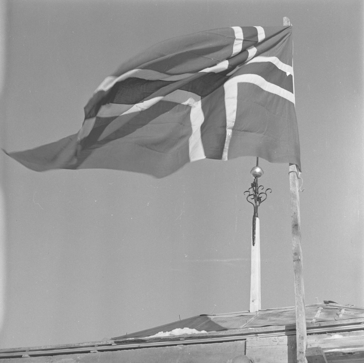 Aust-Agder-Museets første byggetrinn  på Langsæ.  Kranselag. Flagget vaiet og i bakgrunnen sees et spir med beslag av smijern.