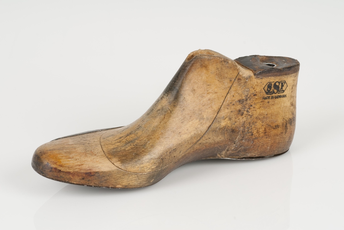En tremodell; hengslet lest
Høyrefot i skostørrelse 44.
Lestekam av skinn.
Såle av metall
