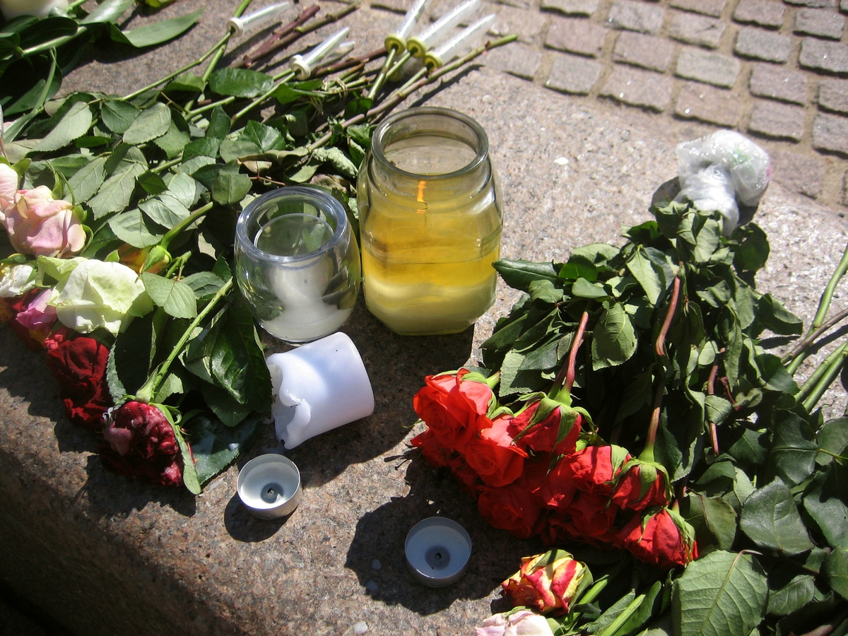 Minner etter terrorhandlingen den 22. juli 2011. Blomster, kort og lykter på fontene på Lillestrøm torg.