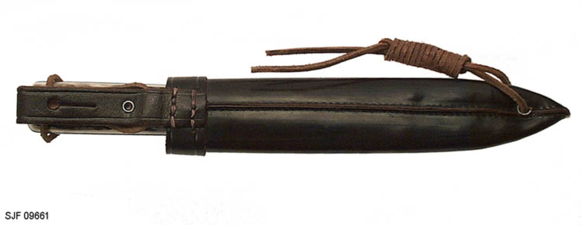 Kniven sitter fast i slira ved at et hull i knivskaftet hvor det er tredd ei reim som er festet til slira. 