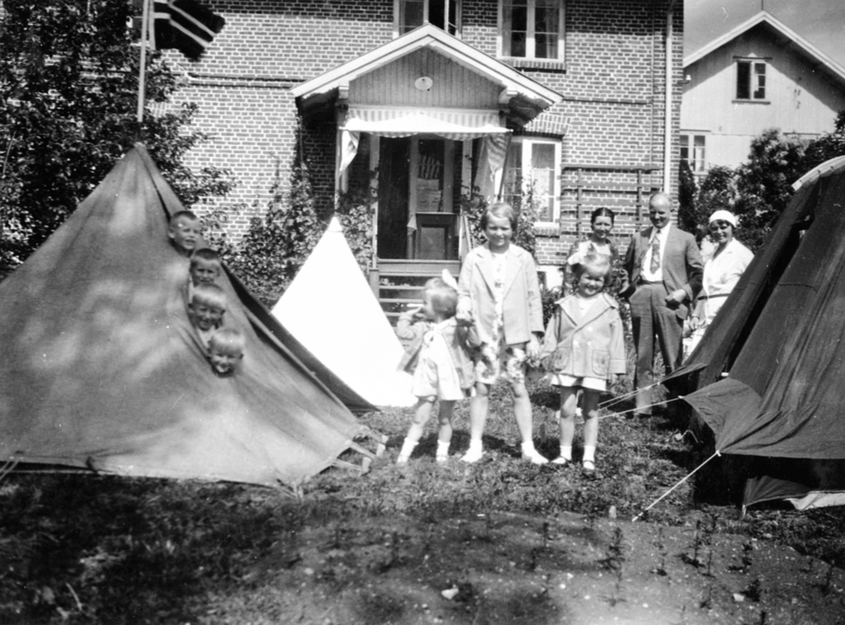 Barn og voksne ved telt i hagen på Granerud gård, Brumunddal. Familien Løken.