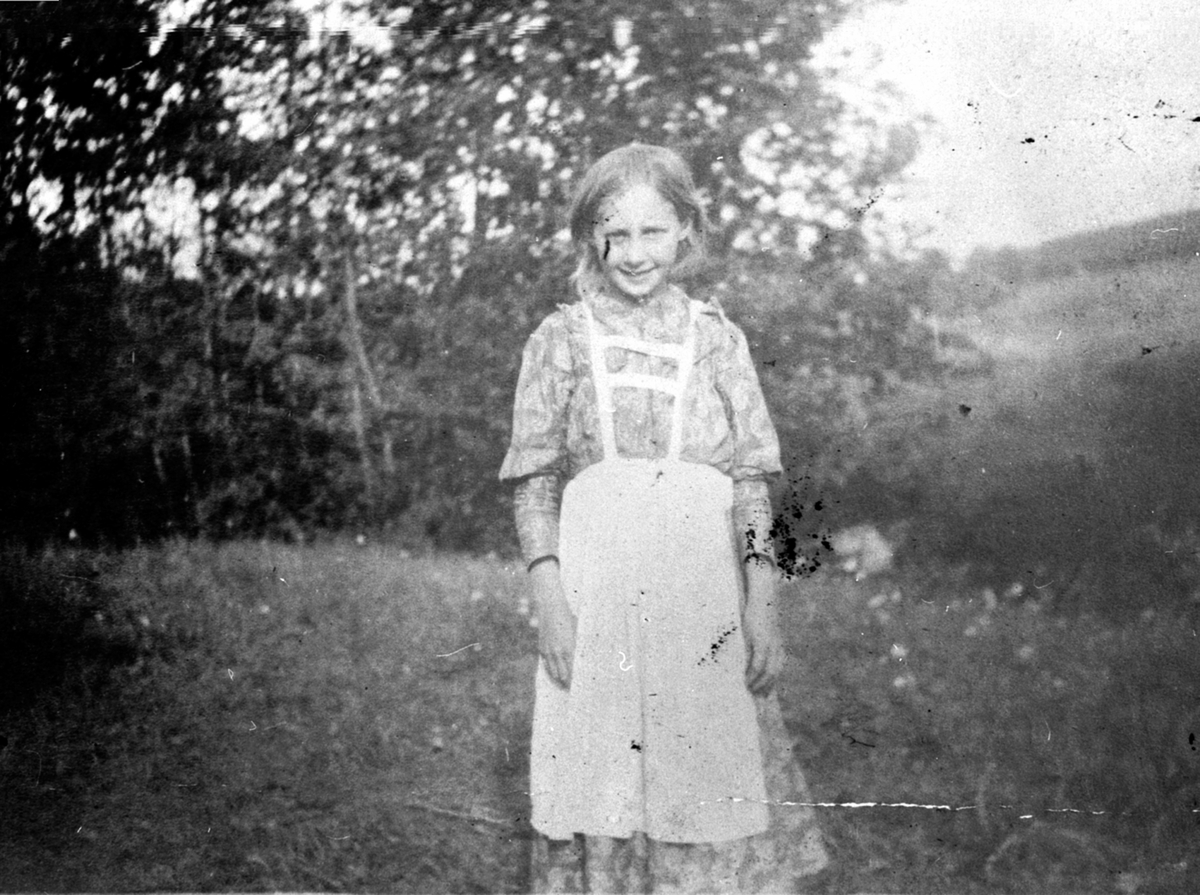 Betsy Evensdatter Raknerud (1893-1974) med forkle. Raknerud søndre, Helgøya.