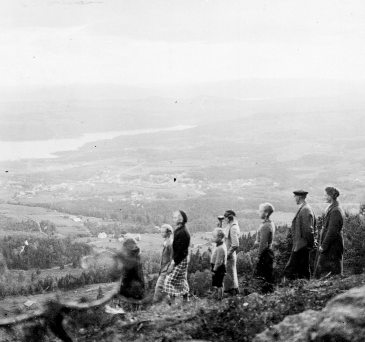 Utsikt fra Høsbjøråsen mot Brumunddal. Gruppe voksne og barn.