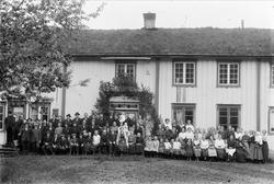 Bryllupsforsamling utenfor stort våningshus..